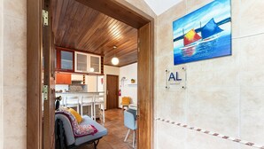 A hotel interior with a dining area, a sofa, and a kitchen. - GuestReady - Casa Âncora (Aveiro)