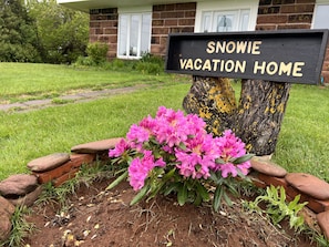 Segnaletica con scritto 'SNOWIE VACATION HOME' e un giardino antistante.