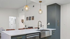 A modern kitchen with a central island, stainless steel appliances, and pendant lighting. - Game, Grill & Lounge Modern S Austin Hangout House Sleeps 10 - Mins to SoCo (Austin)
