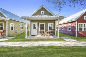 A row of single-story houses with a porch, a small table, and chairs.