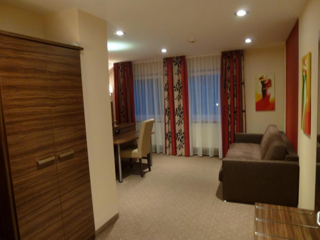 Una habitación con zona de comedor, sofá y armario.