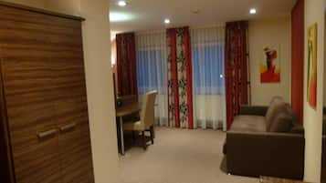 Una habitación con zona de comedor, sofá y armario.