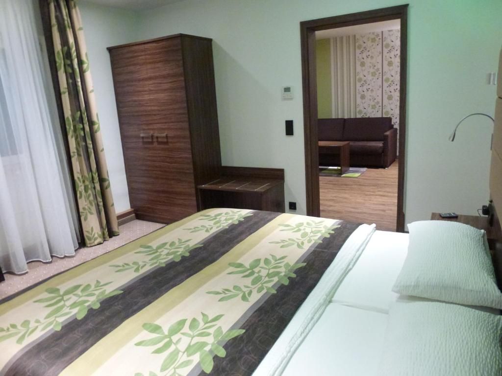 Un dormitorio con una cama, un armario, una mesita y un espejo.