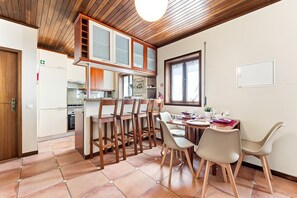 A kitchen with wooden cabinets, a dining table with chairs, and a window.