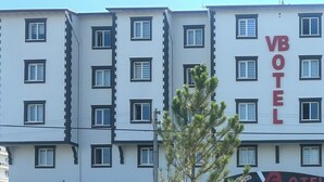 Un edificio de varios pisos con un letrero que dice 'VBOTEL', indicando que es un hotel.