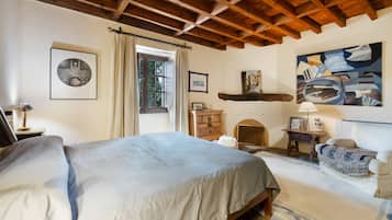 Un dormitorio con cama, cómoda, silla y un cuadro en la pared.