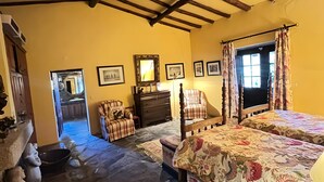 Una habitación con una cama, una silla, un tocador y un espejo.