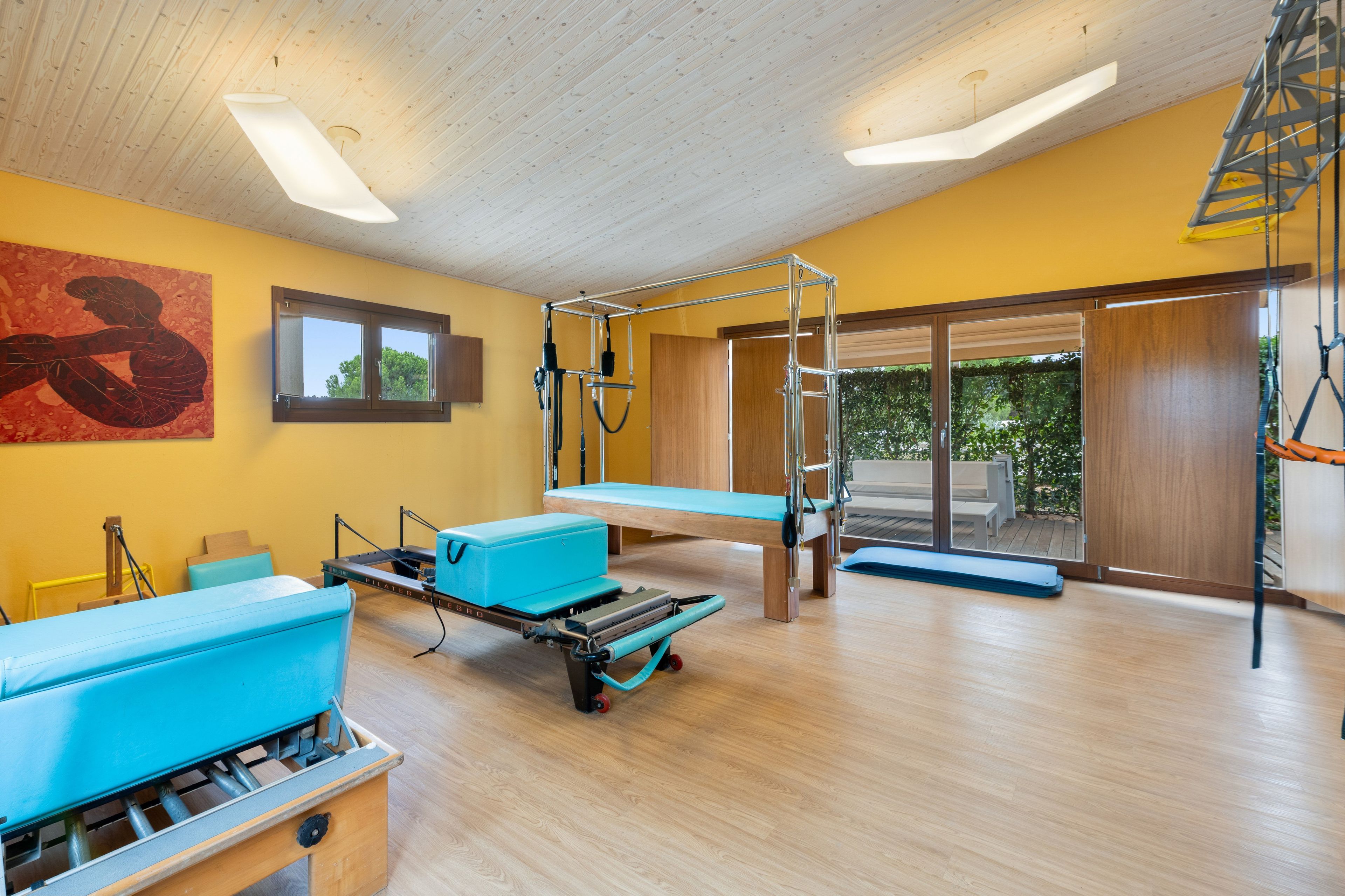Una habitación con techo de madera, un ventanal y vistas al exterior con vegetación.