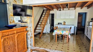 Una cucina con un tavolo da pranzo, mobili in legno e pavimento piastrellato.