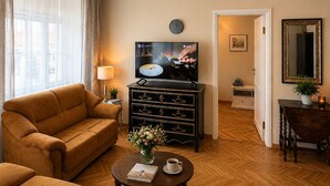 Una sala de estar con sofá, mesa de centro, televisor y espejo.
