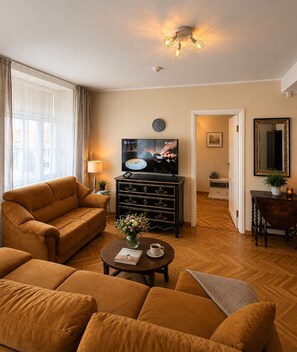 Ein Wohnzimmer mit Sofa, Couchtisch, Fernseher und Spiegel.