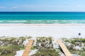 A beach with a wooden boardwalk leading to the water, sandy beach, and clear blue ocean. - Gulf-Front Luxury Home with Private Pool, Beach Access & Bikes! (Panama City Beach)
