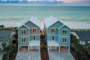 A beachfront property with two-story houses, a central walkway, and a view of the ocean. - Gulf-Front Luxury Home with Private Pool, Beach Access & Bikes! (Panama City Beach)