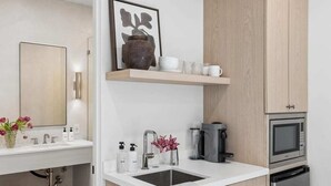 Una cocina moderna con fregadero, cafetera, microondas y lavavajillas.