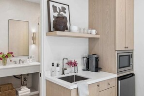 A modern kitchen with a sink, coffee maker, microwave, and dishwasher. - Casa Iglesia Studio 212 (Santa Barbara)