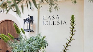 A wall with 'CASA IGLESIA' text, a wooden door, and a lantern. - Casa Iglesia Studio 205 (Santa Barbara)