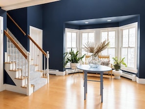 Ein modernes Interieur mit einer Treppe zu einer privaten Einheit, einem gemeinsamen Eingangsbereich und großen Fenstern.