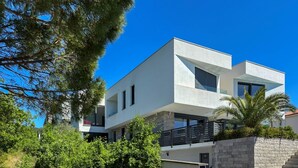 Um edifício moderno de dois andares com telhado plano, grandes janelas e fachada de pedra.