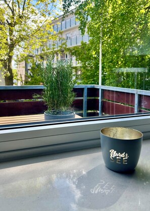 Ein Fenster mit einem Blumentopf und einer Tasse auf einem Tisch.