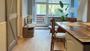 Eine Küche mit einer Holzausziehtheke, einer hängenden Pendelleuchte und Blick durch das Fenster.