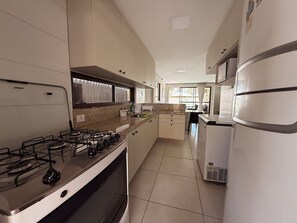 Una cocina equipada con estufa a gas, horno y refrigerador.