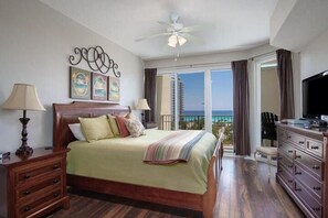 A hotel room with a bed, a dresser, a television, and a balcony with a view. - Ariel Dunes I 610- Emerald Eden (Miramar Beach)