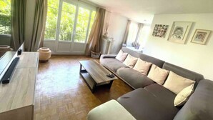 Een moderne woonkamer met een bank, salontafel en een groot raam.