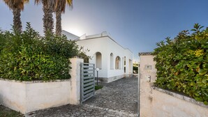 Un edifici blanc amb finestres d'arc i entrada enllosida.