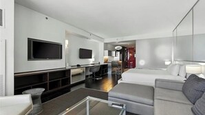 A modern hotel room with a sofa, a TV, a desk, and a bed. - Palms Place Hotel HighFloor StripView with Balcony (Las Vegas)