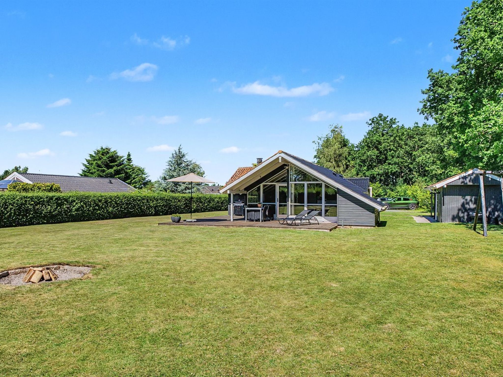 A house with a sloped roof, a covered patio, and a fenced yard.