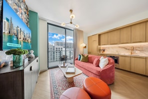 A modern living room with a sofa, ottoman, and a coffee table. - Nomad condo (Miami)