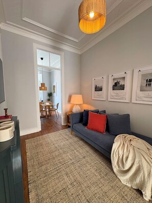 A living room with a sofa, a lamp, and framed pictures on the wall. - Casa Fataca (Grândola)