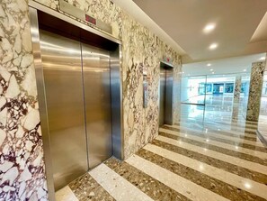 A marble-floored corridor with two elevators and a glass entrance to a lobby. - Isla Verde Beach/Self Check-in, 1 Parking, Pool (Carolina)