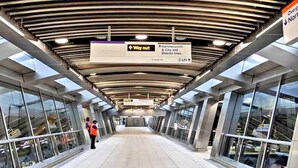 A covered pedestrian walkway with directional signs, glass railings, and a modern architectural design. - Air conditioner 2 Bedroom central flat (London)