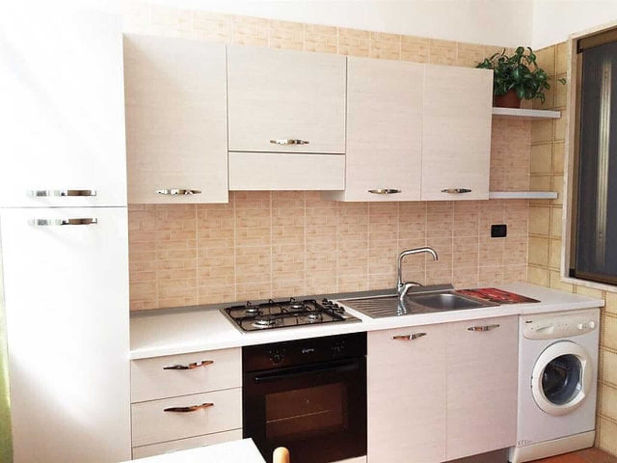 Réfrigérateur, un four, surface de cuisson, vaisselle et ustensiles