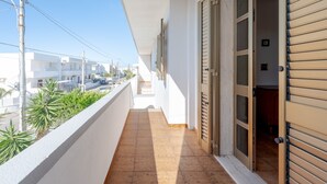 A narrow balcony with a tiled floor, white walls, and a door leading to an interior space. - Apartment 'Villa Mezzaluna - Cielo' with Balcony and Air Conditioning (San Foca)
