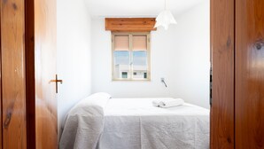 A bedroom with a bed, a window with blinds, a wooden ceiling, and a white wall. - Apartment 'Villa Mezzaluna - Cielo' with Balcony and Air Conditioning (San Foca)