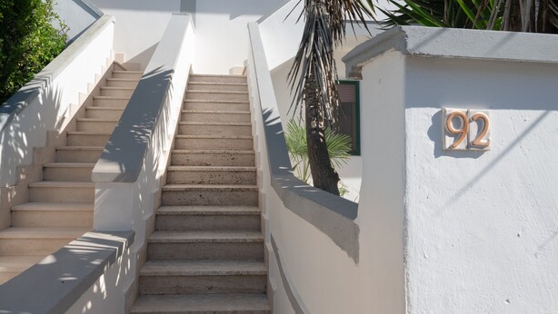 A staircase leading to a white wall with the number 92. - Apartment 'Villa Mezzaluna - Cielo' with Balcony and Air Conditioning (San Foca)