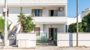 A two-story building with a balcony, a staircase, and a gate. - Apartment 'Villa Mezzaluna - Cielo' with Balcony and Air Conditioning (San Foca)