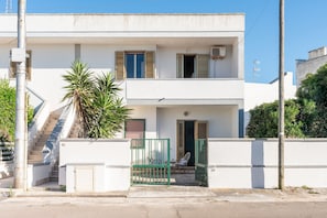 A two-story building with a balcony, a staircase, and a gate. - Apartment 'Villa Mezzaluna - Cielo' with Balcony and Air Conditioning (San Foca)