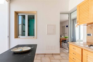 Eine Küche mit Fenster, einem Esstisch und einer Arbeitsplatte.