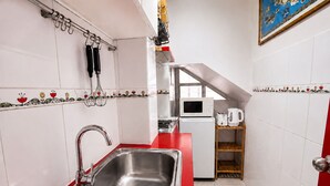 A compact kitchen with a stainless steel sink, a microwave, and a toaster on a white countertop. - Luminous Home Studio with privileged view to the Park. Steps away from Metro Bilbao. Wifi (Providencia)