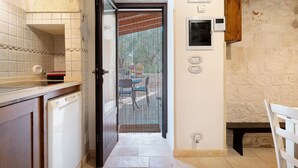 Una cocina con lavavajillas, un armario de madera y una puerta que da a un área exterior.