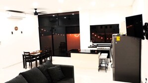 Eine moderne Küche mit Gasherd, Kühlschrank und Essbereich mit Tisch und Stühlen.