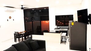 A modern kitchen with a gas stove, a refrigerator, and a dining area with a table and chairs. - Ecohabitat - Mayan House (Puerto Morelos)