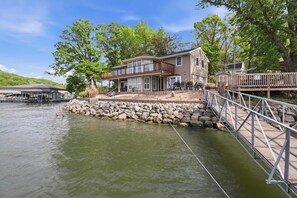 A waterfront property with a large house, a dock, and a bridge. - Lakefront Home With Stunning Lake Views (Sunrise Beach)