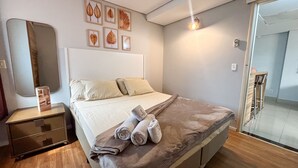 A modern bedroom with a bed, bedside tables, a mirror, and wall art. - SHB - Beach Vibe Estilo Vista Mar Sacada (Santos)