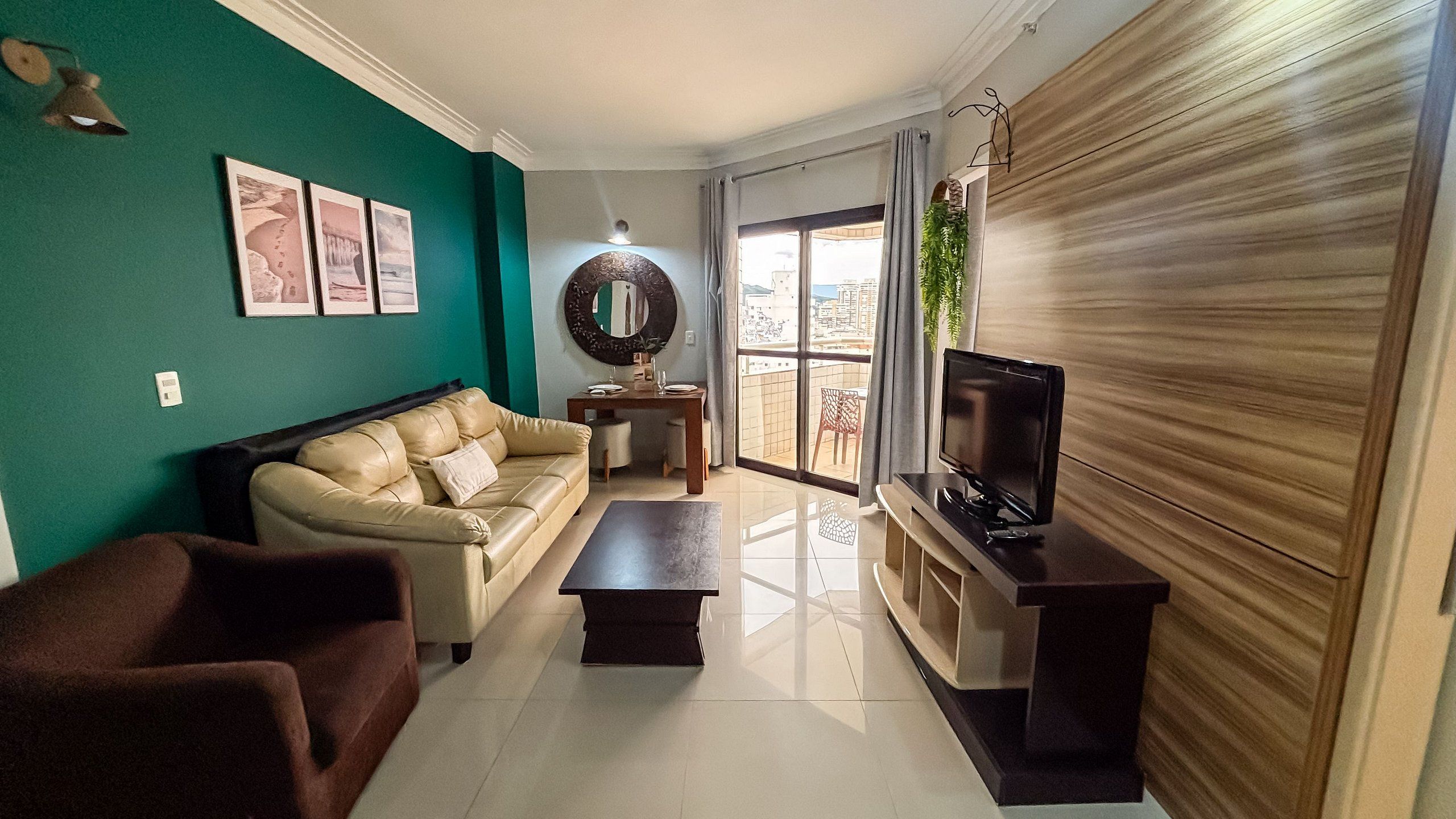 Una sala de estar con sofá, mesa de centro, televisor y comedor con mesa y sillas.