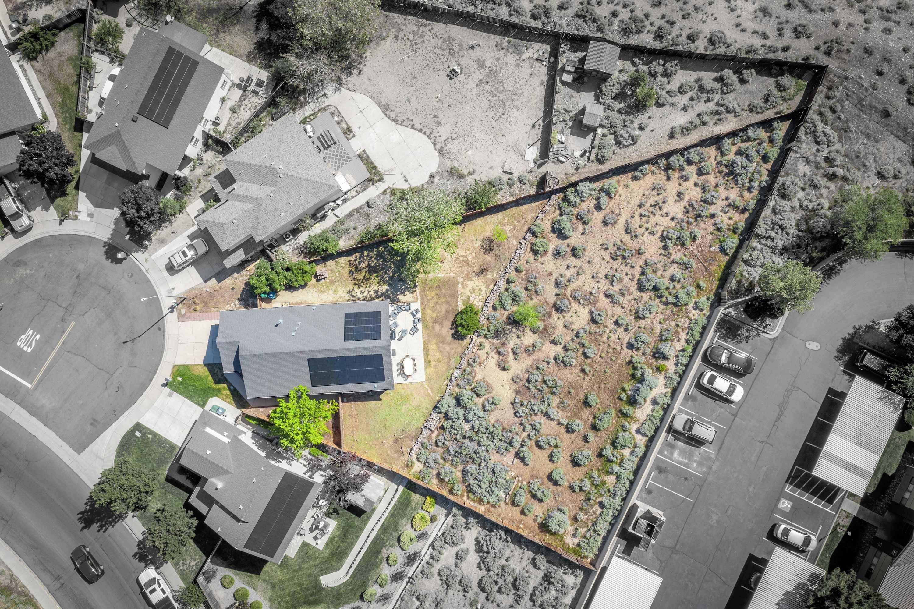 Vista aérea de una zona residencial con casas, un estacionamiento y un jardín ajardinado.