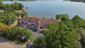 A large building with a parking lot and a lake in the background. - Delton Dawn - Luxury at Delton Grand (Wisconsin Dells)